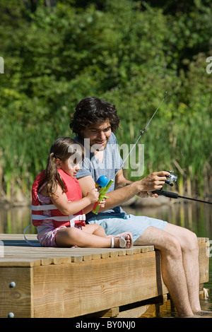 Padre e figlia pesca dal molo Foto Stock