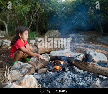 Giovane ragazza in un accampamento min una foresta mediterranea Foto Stock