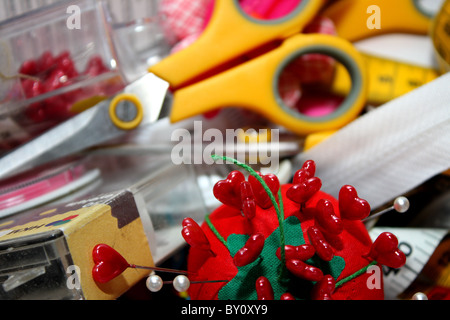 Un gruppo di accessori per il cucito e merceria in un sarti e sarti da donna Scatola da cucito Foto Stock