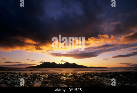 Tramonto sull'Isola di Rum (Rhum) come visto da Laig Bay sull'Isola di Eigg Foto Stock