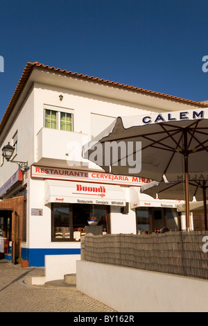 Un ristorante si erge inondata di sole a Porto Covo in portogallo Alentejo costa. Il ristorante dispone di ombrelloni all'esterno. Foto Stock