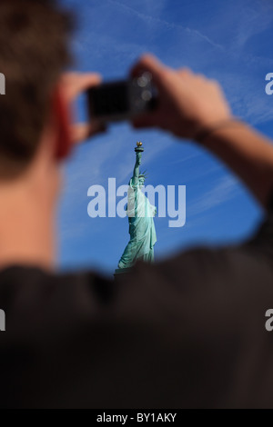 La Statua della Libertà fotografata attraverso il braccio di un turista, New York City, Stati Uniti d'America Foto Stock