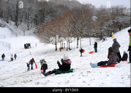 Slittino sulla collina borbotta qualcosa di fresco di neve caduti si blocca in alberi i bambini guardano per il miglior angolo di discesa. Foto Stock