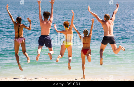 Ritratto di cinque adolescenti saltando nel lago simultaneamente Foto Stock