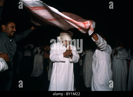 Bedouin groom danze nel matrimonio tradizionale processione di strada per la sposa della casa. El Tur, Sinai, Egitto Foto Stock