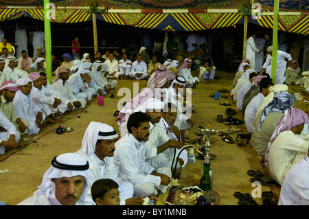 Ospiti seduti attendono intrattenimento durante un beduino tradizionale celebrazione di matrimonio. El Tur, Sinai, Egitto Foto Stock