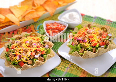 Due taco insalate con la salsa e panna acida e chip sul lato Foto Stock