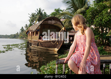 India Kerala. Giovane ragazza su una vacanza in famiglia in Kerala Backwaters, houseboat in background. (MR) Foto Stock
