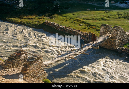 India, Jammu e Kashmir Ladakh e Zanskar, Kargyak Valley. Un uomo Zanskari monaco e attraversare il fiume Kargyak su un legno tradizionale Foto Stock