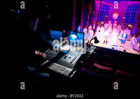 Un uomo alla guida di una illuminazione digitale scheda desk in un teatro, disegnando le luci per una fase di produzione, REGNO UNITO Foto Stock