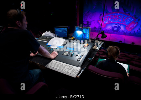 Un uomo alla guida di una illuminazione digitale scheda desk in un teatro, disegnando le luci per una fase di produzione, REGNO UNITO Foto Stock