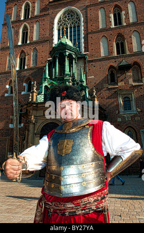 Interessante il ritratto di uomo blindato in costume con la spada nella piazza principale del mercato bella Cracovia Polonia Foto Stock