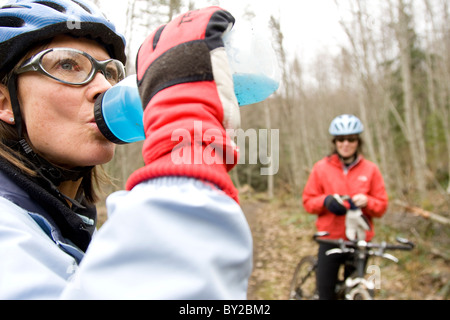 Due mountain bike fuori di equitazione a binario unico sentiero attraverso la foresta. Foto Stock