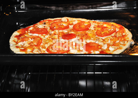 Hot home pizza fatta per la cottura in forno Foto Stock