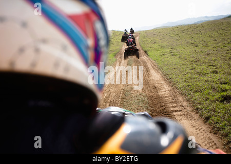 Un gruppo di uomo corse loro quads attraverso una strada sterrata da Catemaco a Queretaro in Veracruz, Messico. Foto Stock