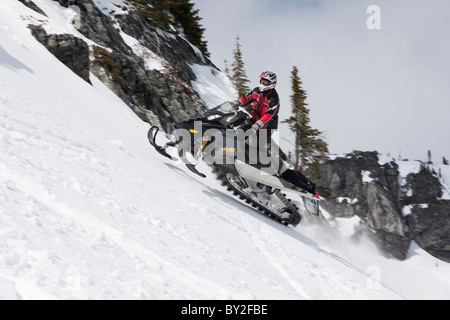 Un uomo riceve una certa quantità di aria durante la guida su una motoslitta fino al lato della montagna Owlshead. Foto Stock