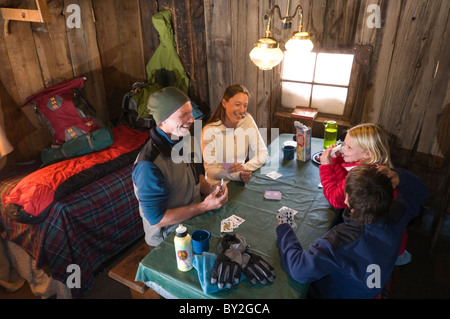 Famiglia giocando a carte sul tavolo a Saint Paul Lodge, Red Mountain Pass, Colorado. Foto Stock