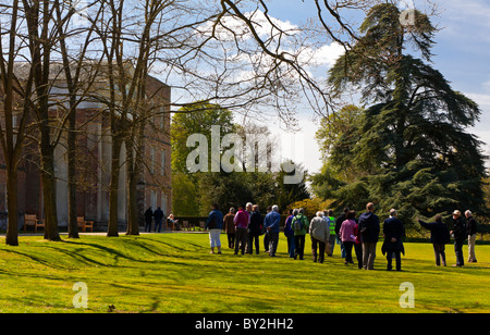 Gruppo di turisti in un tour guidato nel giardino di una dimora signorile in Inghilterra Foto Stock