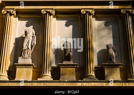 Statue senza testa Gulhane Park Istanbul Turchia // ISTANBUL, Turchia - statue senza testa a Gulhane Parki fuori dall'ingresso del Palazzo Topkapi di Istanbul. Queste figure antiche o classiche, ricoperte da abiti scorrevoli, si stagliano in modo prominente tra grandi colonne scanalate, immerse nella suggestiva luce del sole che proietta lunghe ombre. Foto Stock
