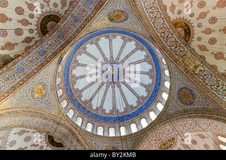 Blue Mosque Dome Interior Istanbul Turchia // ISTANBUL, Turchia — Moschea del Sultano Ahmed (turco: Sultanahmet Camii), conosciuta popolarmente come la Moschea Blu, è una moschea musulmana (sunnita) nel centro del quartiere della città vecchia di Istanbul, Sultanahmet. Fu commissionato dal sultano Ahmed i e completato nel 1616. La moschea è rinomata per i suoi splendidi interni, in particolare la cupola principale, che è adornata con migliaia di piastrelle blu Iznik e intricata calligrafia, creando uno spettacolo visivo mozzafiato. Foto Stock