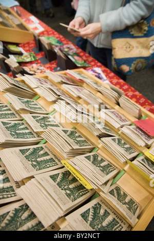 Una donna esamina un pacchetto di semi da agricoltura biologica di fronte a un display all annuale Vancouver squallida sabato lo scambio di sementi e di vendita. Foto Stock