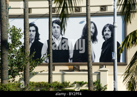 Il picco dei Beatles fuori da dietro palme sul loro cartellone per i tunes vicino al Mercato degli Agricoltori in Los Angeles Foto Stock