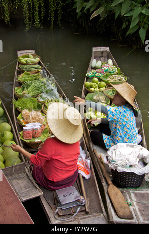 Due signore vendono frutta e altri prodotti alimentari nei tradizionali barche di legno su un canale laterale in 'Thai Cultural Village' Foto Stock