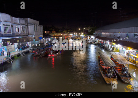 Una vista dal ponte di notte di barche sul canale laterale al mercato galleggiante di Amphawa in Samut Songkhram Foto Stock