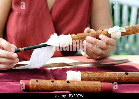 Una donna di pulizia di un flauto Foto Stock