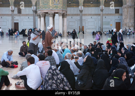 Visitatori ascoltare attentamente un uomo santo nel cortile della Grande Moschea Umayyad, Damasco, Siria Foto Stock