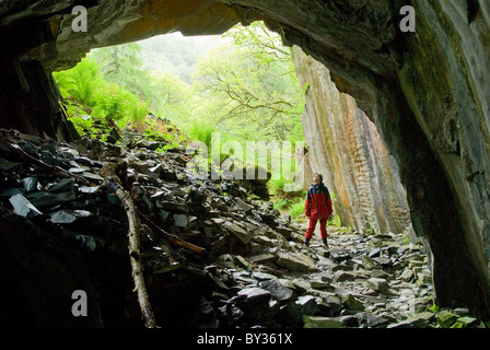 Donna in piedi all'entrata di una caverna, Parco Nazionale del Distretto dei Laghi, Cumbria, England, Regno Unito, Europa Foto Stock