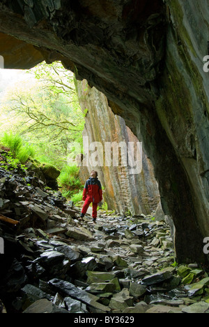 Donna in piedi all'entrata di una caverna, Parco Nazionale del Distretto dei Laghi, Cumbria, England, Regno Unito, Europa Foto Stock