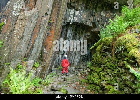 Donna in piedi all'entrata di una caverna, Parco Nazionale del Distretto dei Laghi, Cumbria, England, Regno Unito, Europa Foto Stock