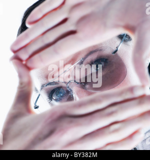 Ritratto di giovane donna che fa il dito su telaio bicchieri Foto Stock