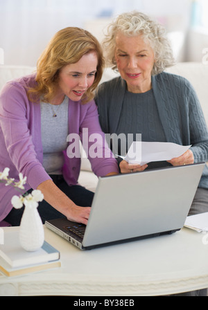 Stati Uniti d'America, New Jersey, Jersey City, madre e figlia utilizzando laptop in salotto Foto Stock