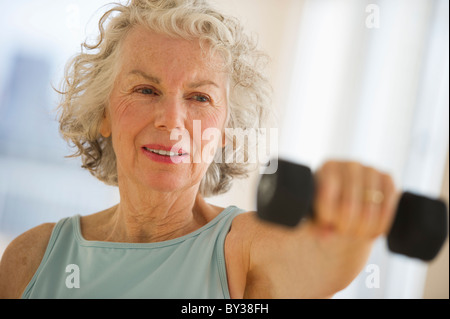 Stati Uniti d'America, New Jersey, Jersey City, Senior donna utilizzando pesi in palestra Foto Stock