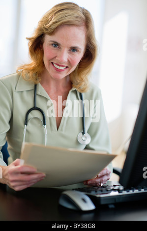 Stati Uniti d'America, New Jersey, Jersey City, ritratto di medico donna azienda medical record in Office Foto Stock