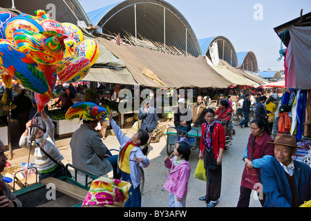 Gli amanti dello shopping a Menghai produrre mercato, nella provincia dello Yunnan, Regione di Xishuangbanna, Repubblica Popolare Cinese. JMH4187 Foto Stock