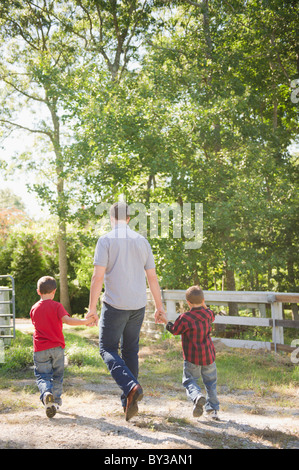 Stati Uniti d'America, New York, Fiandre, padre di due figli (4-5, 8-9) passeggiate in fattoria Foto Stock