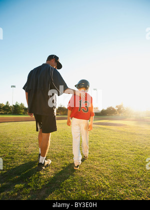 Stati Uniti, California, Ladera Ranch, uomo e ragazzo (10-11) camminando sul campo di baseball Foto Stock