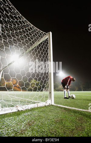 Stati Uniti, California, Ladera Ranch, il goalie illuminato sul campo di calcio di notte Foto Stock