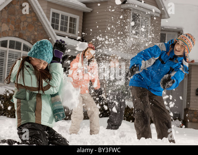 Stati Uniti d'America, Utah, Provo, ragazzi (10-11, 12-13) e le ragazze (10-11, 16-17) avente lotta a palle di neve davanti a casa Foto Stock