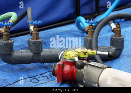 Valvole su una tubazione flessibile in una vasca per chimico washoff da un pericoloso hazmat fuoriuscita di sostanze chimiche ed acqua di pulitura bagno industriale Foto Stock