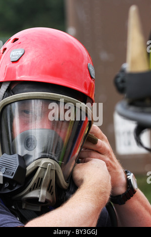 Un vigile del fuoco mettendo su un apparato di respirazione marcia a una sostanza chimica haz mat spill incident Foto Stock