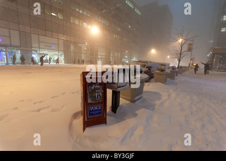 Scatole di giornale sulla 6th Avenue coperto di una spessa coltre di neve durante la grande nevicata nella città di New York nel Natale 2010 Foto Stock