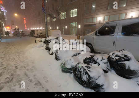 Sacchi della spazzatura coperto di neve spessa coperta sui 43rd Street a New York City durante la tempesta di neve di Natale 2010 Foto Stock