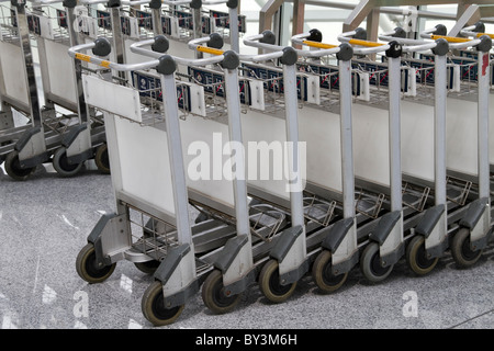 Fila di carrelli per bagagli in aeroporto di Pechino Foto Stock