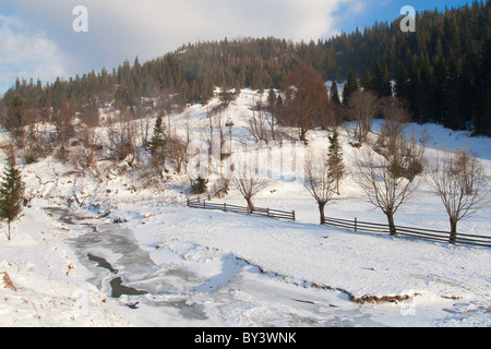 Frozen river on a winter mountain landscape Foto Stock