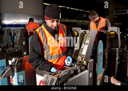 Ingegneri lavorare di notte per mantenere barriere biglietteria presso canary wharf sulla stazione metropolitana di londra Foto Stock