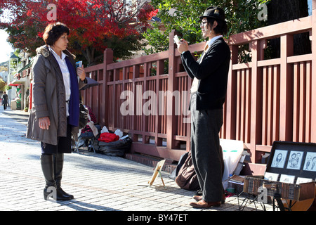 Ritrattista disegno lady nel Quartiere di Kitano di Kobe, provincia di Kansai, Central Honshu, Giappone. Foto Stock